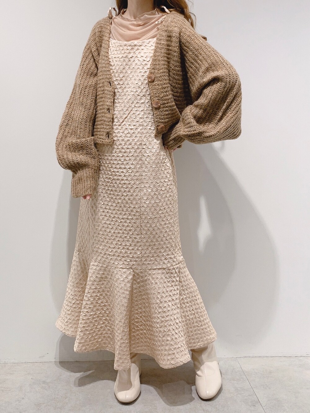 ブラウン系のカーディガン/ボレロ、ベージュ系のワンピース、ホワイト系のブーツを着用したレディースの秋コーディネートの1枚目の写真