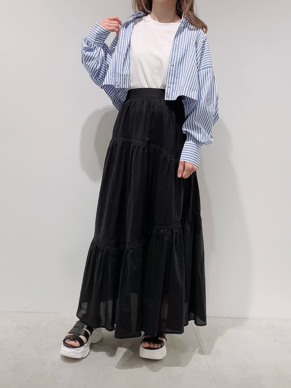 ブルー系のシャツ/ブラウス、ホワイト系のTシャツ/カットソー、ブラック系のスカートを着用したレディースの春コーディネートの1枚目の写真