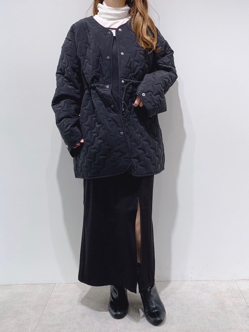 ブラック系のノーカラーコート、ホワイト系のTシャツ/カットソー、ブラック系のワンピースを着用したレディースの冬コーディネートの1枚目の写真