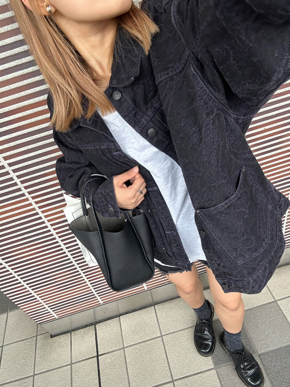 ブラック系のデニムジャケット、グレー系のTシャツ/カットソー、ブラック系のブーツを着用したレディースの秋コーディネートの1枚目の写真