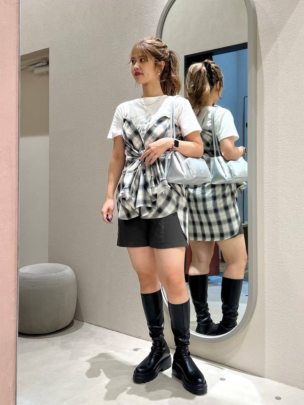 ホワイト系のシャツ/ブラウス、ブラック系のブーツ、ピンク系のショルダーバッグを着用したレディースの秋コーディネートの1枚目の写真