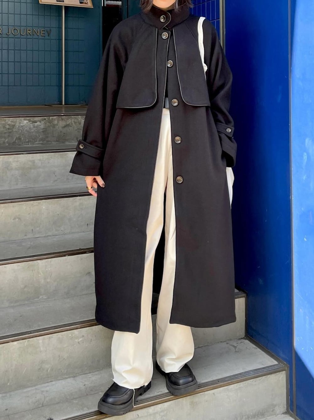 ホワイト系のショルダーバッグ、ブラック系のその他アウター、ホワイト系のその他を着用したレディースの春コーディネートの1枚目の写真