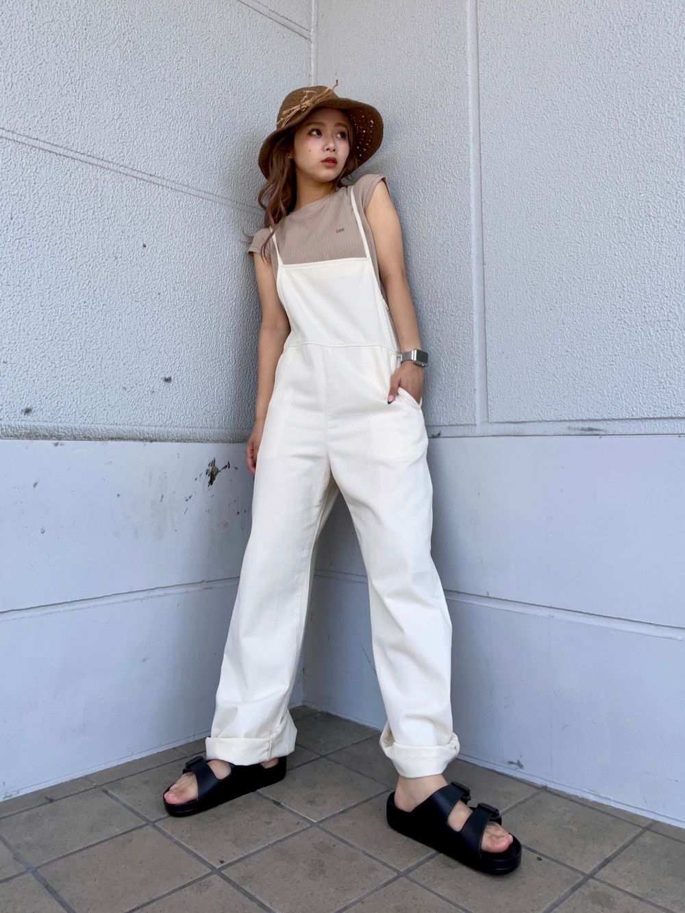 ホワイト系のサロペット/オーバーオール、ブラック系のサンダル、ブラウン系のハットを着用したレディースの夏コーディネートの1枚目の写真