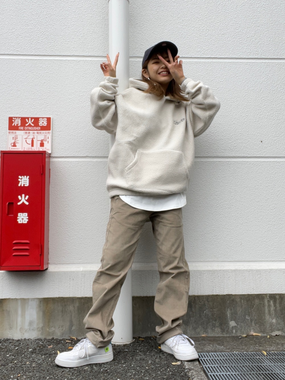 グレー系のパーカー、ホワイト系のTシャツ/カットソー、ベージュ系のパンツを着用したレディースの秋コーディネートの1枚目の写真