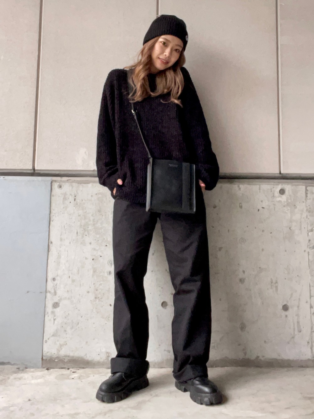 ブラック系のアンサンブル、ブラック系のショルダーバッグ、ブラック系のチノパンツを着用したレディースの冬コーディネートの1枚目の写真