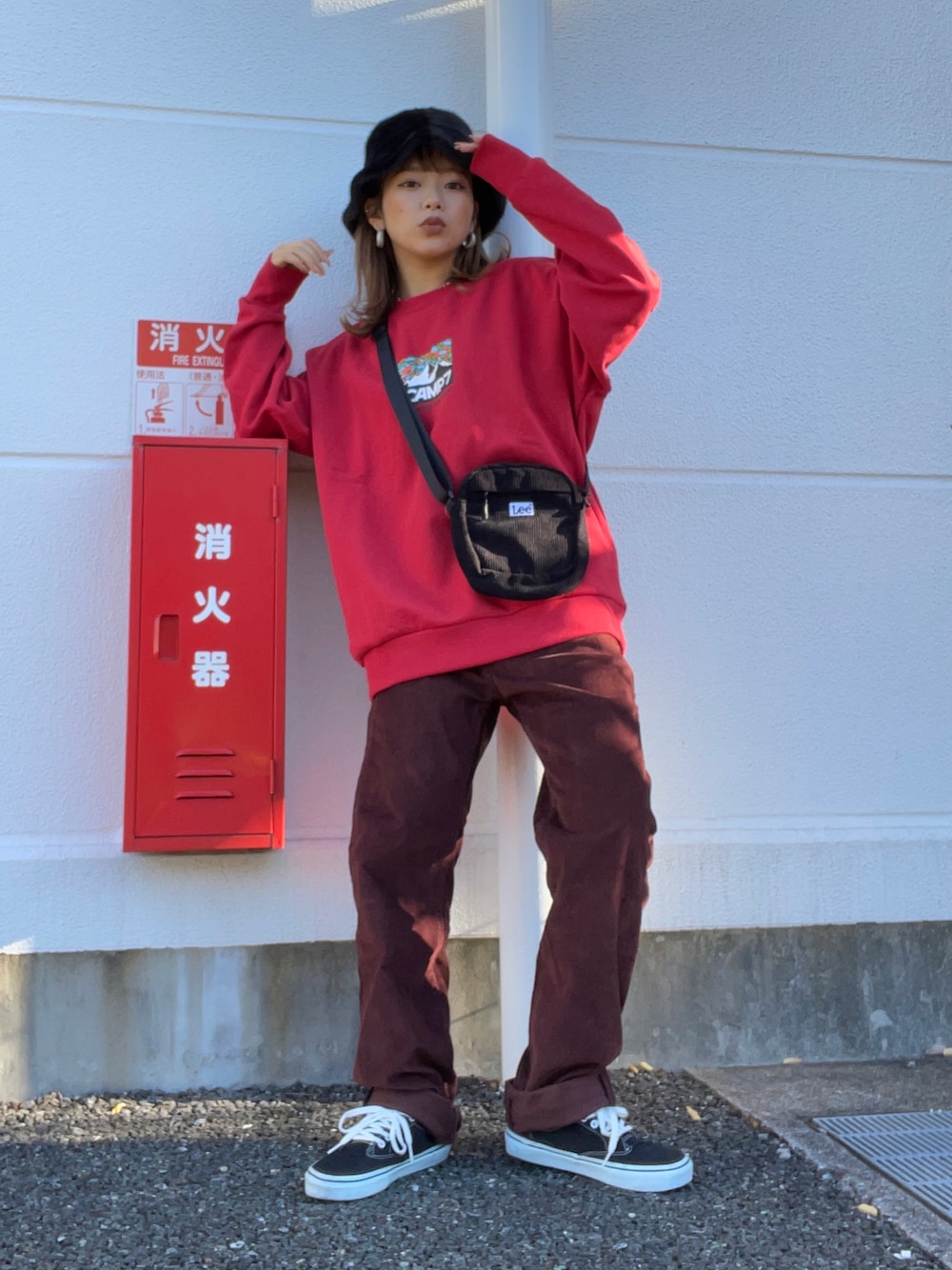 レッド系のスウェット、ブラック系のショルダーバッグ、レッド系のパンツを着用したレディースの秋コーディネートの1枚目の写真