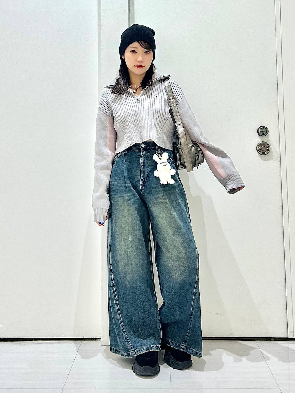 ブルー系のデニムパンツ、グレー系のショルダーバッグ、グレー系のニット/セーターを着用したレディースの秋コーディネートの1枚目の写真