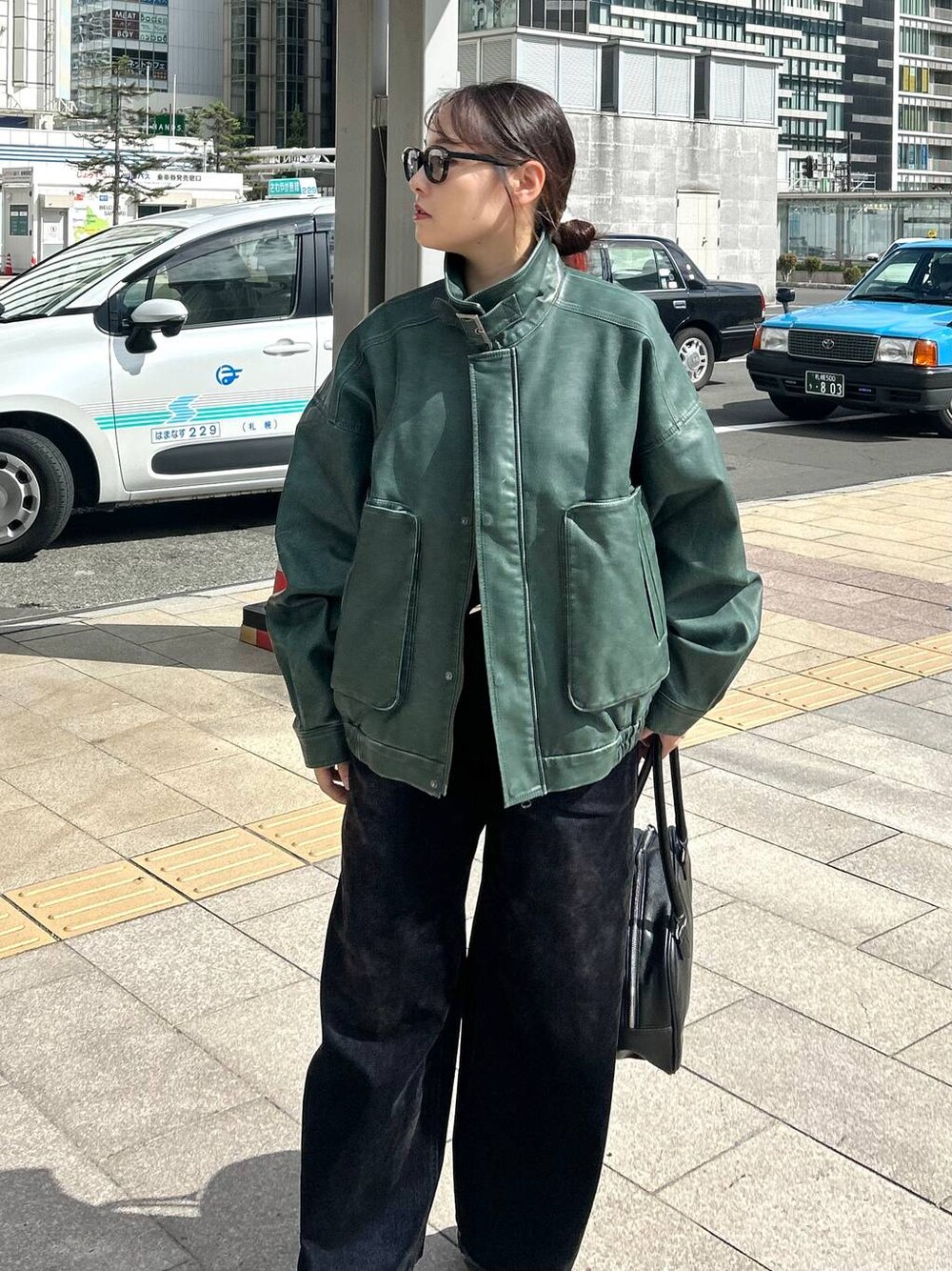 ブラック系のデニムパンツ、グリーン系のブルゾンを着用したレディースの秋コーディネートの1枚目の写真