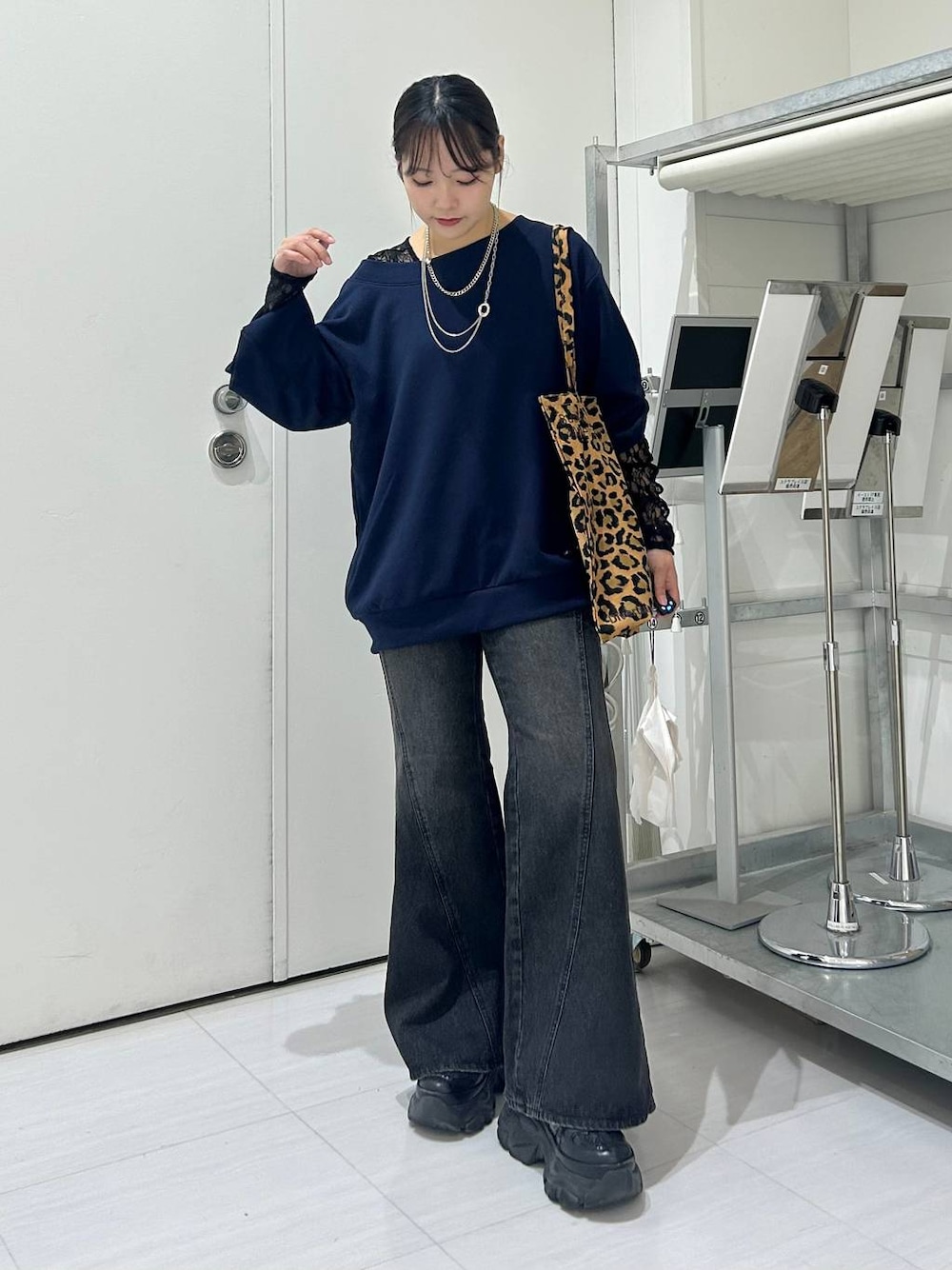 ブラック系のスニーカー、ブルー系のデニムパンツ、ブラック系のTシャツ/カットソーを着用したレディースの秋コーディネートの1枚目の写真