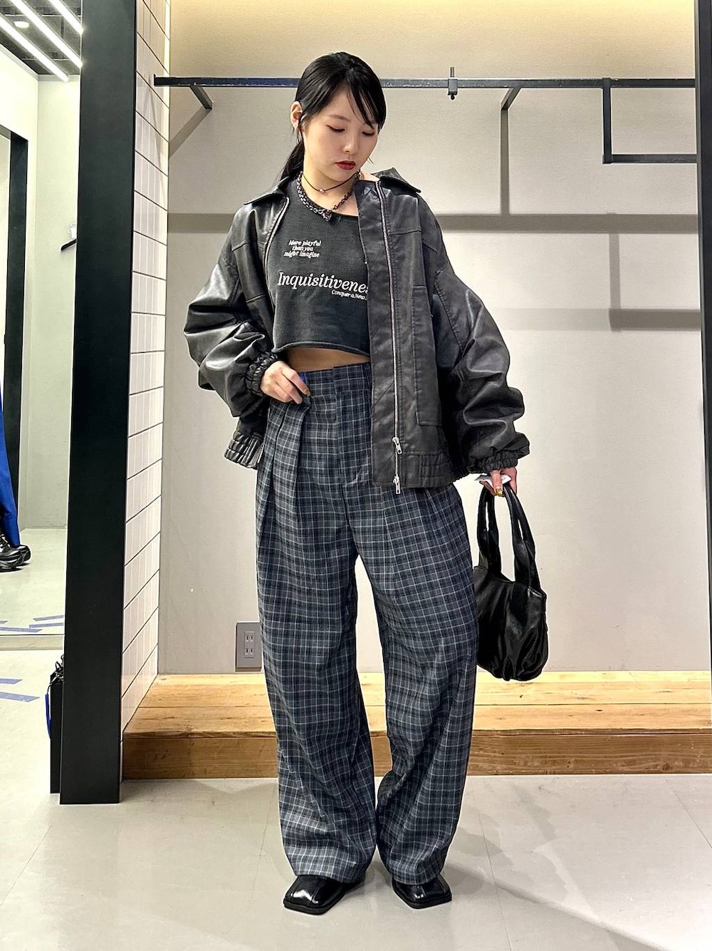 グレー系のブルゾン、ブラック系のブーツ、グレー系のスラックスを着用したレディースの秋コーディネートの1枚目の写真