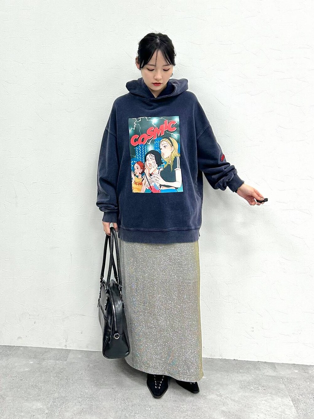 ブラック系のボストンバッグ、ブラック系のパンプス、グレー系のスカートを着用したレディースの冬コーディネートの1枚目の写真
