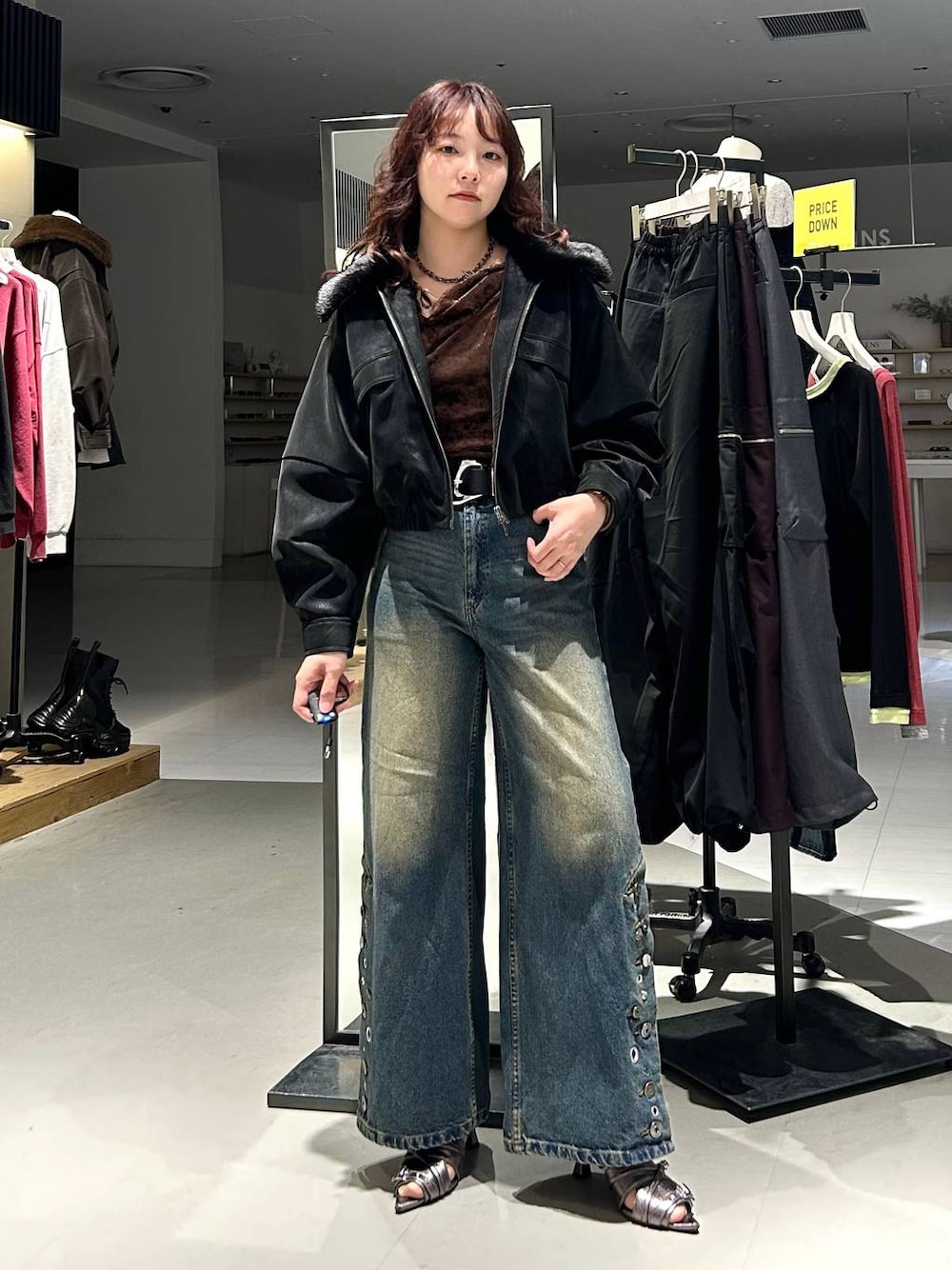 ブラック系のブルゾン、ブルー系のデニムパンツ、ブラウン系のTシャツ/カットソーを着用したレディースの秋コーディネートの1枚目の写真