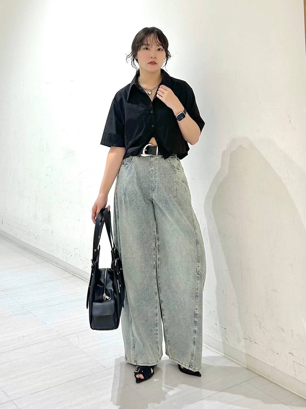 ブルー系のデニムパンツ、ブラック系のサンダル、ブラック系のベルトを着用したレディースの夏コーディネートの1枚目の写真