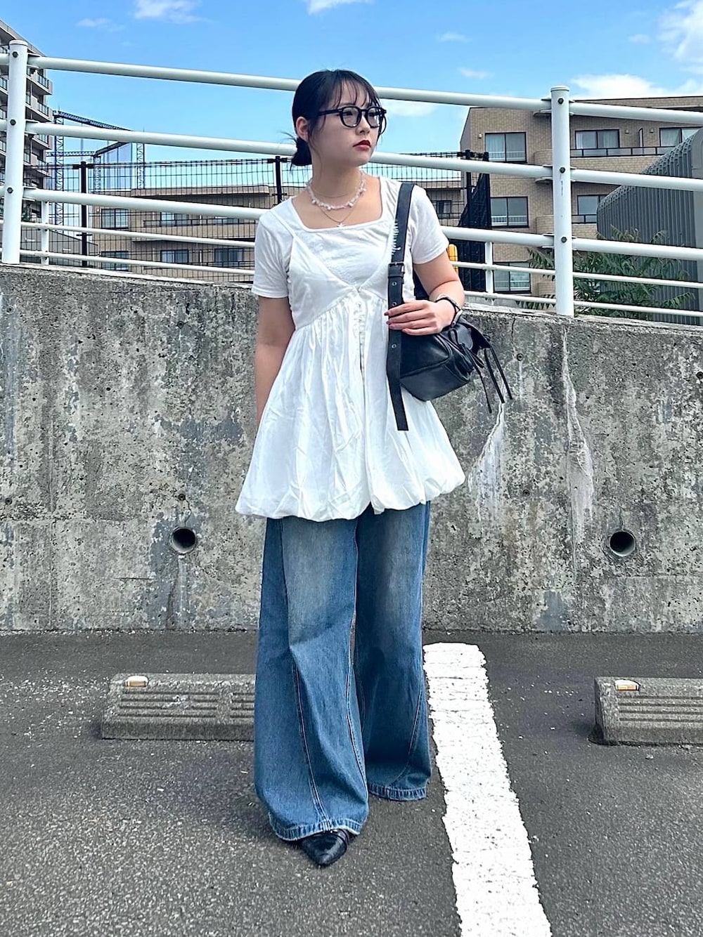 ブルー系のデニムパンツ、ホワイト系のTシャツ/カットソー、ホワイト系のキャミソールを着用したレディースの夏コーディネートの1枚目の写真