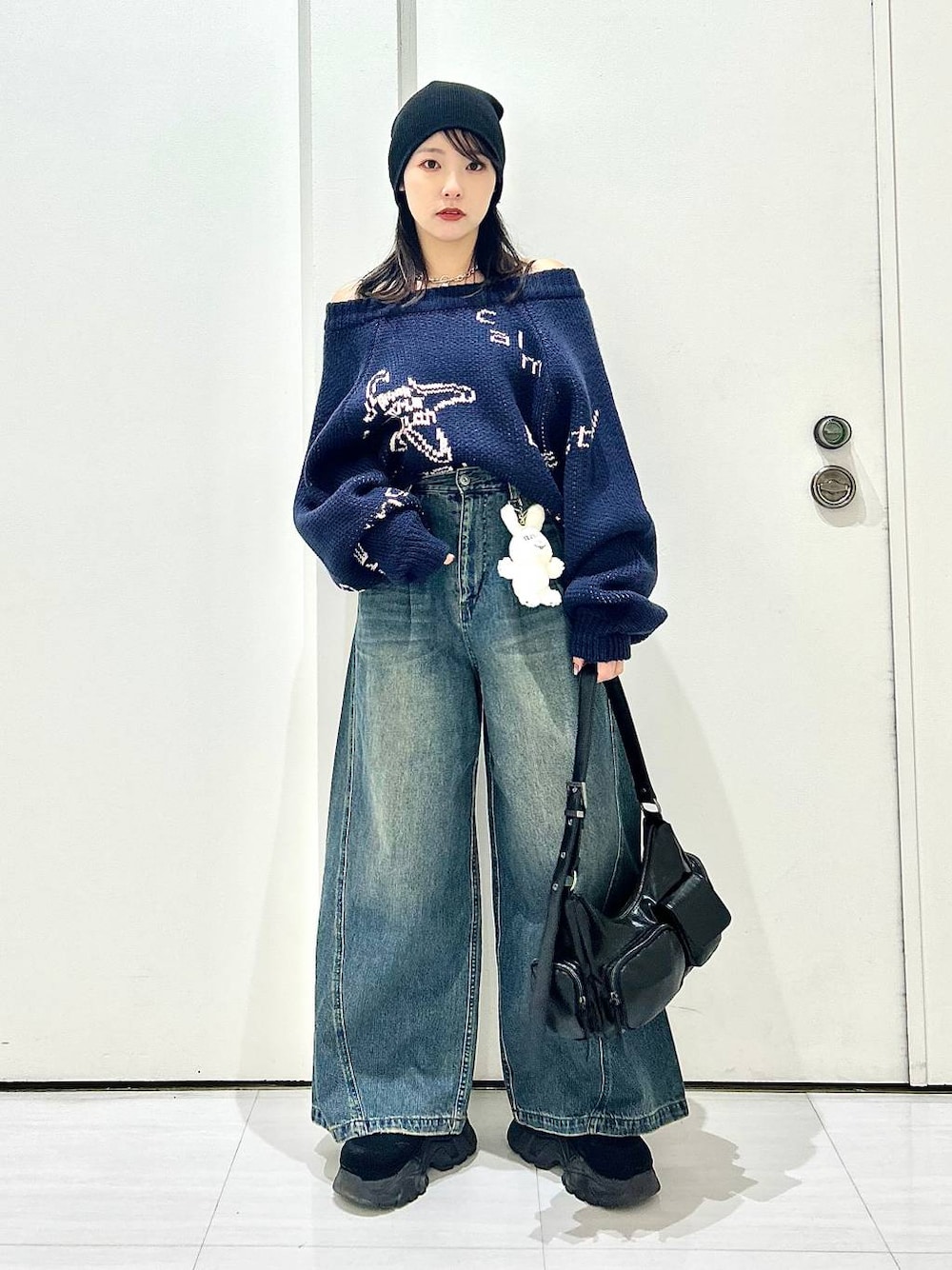 ブルー系のデニムパンツ、ブラック系のショルダーバッグ、ブルー系のニット/セーターを着用したレディースの秋コーディネートの1枚目の写真