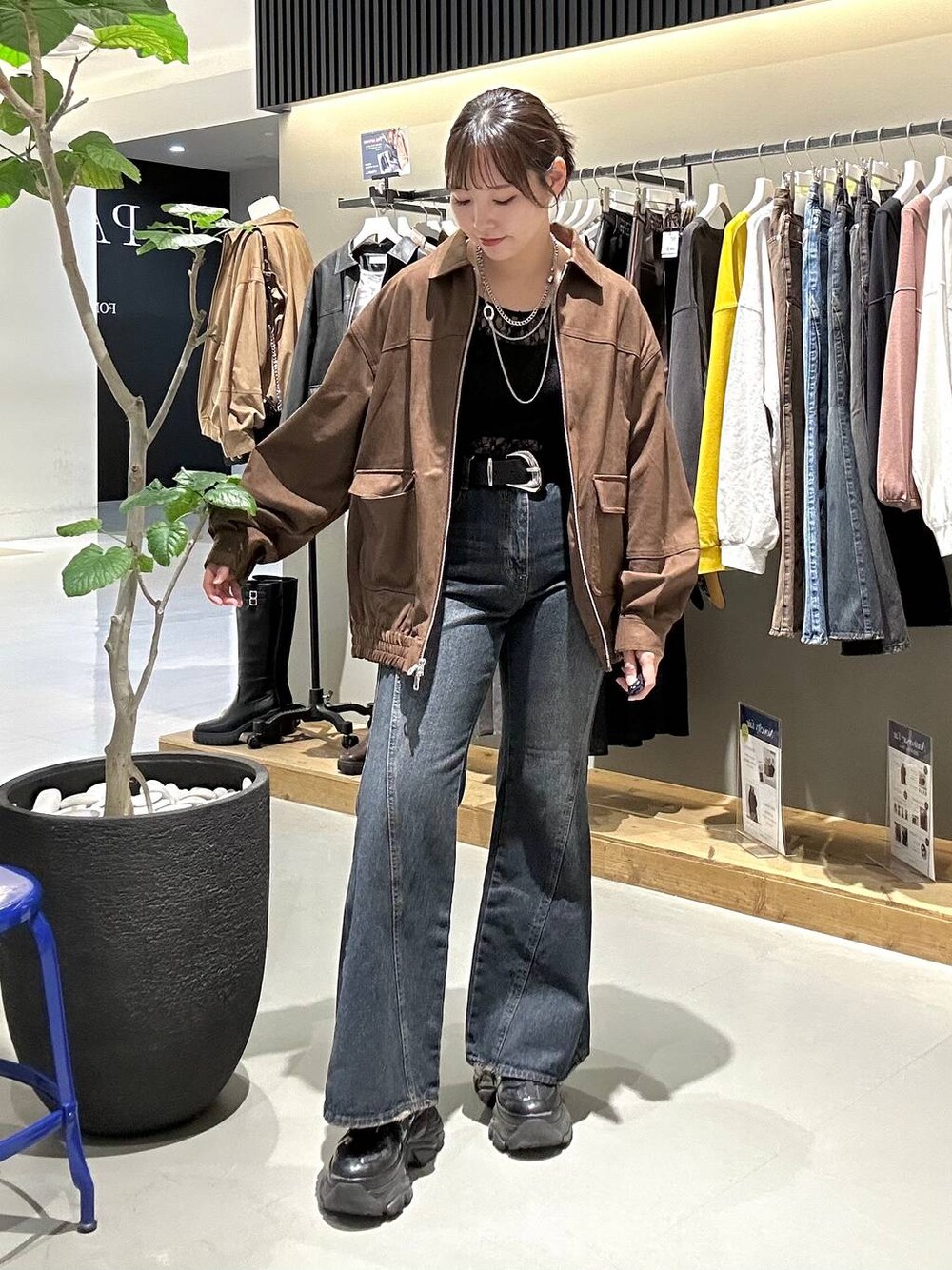 ブラック系のスニーカー、ブルー系のデニムパンツ、ブラック系のTシャツ/カットソーを着用したレディースの秋コーディネートの1枚目の写真