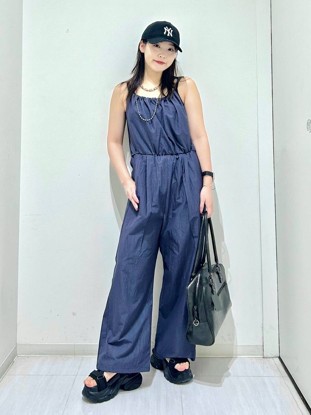 ブラック系のボストンバッグ、ブラック系のサンダル、ブラック系のキャミソールを着用したレディースの春コーディネートの1枚目の写真