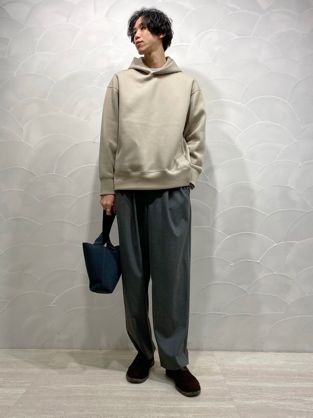 ベージュ系のパーカー、イエロー系のスラックス、ブラウン系のブーツを着用したメンズの秋コーディネートの1枚目の写真