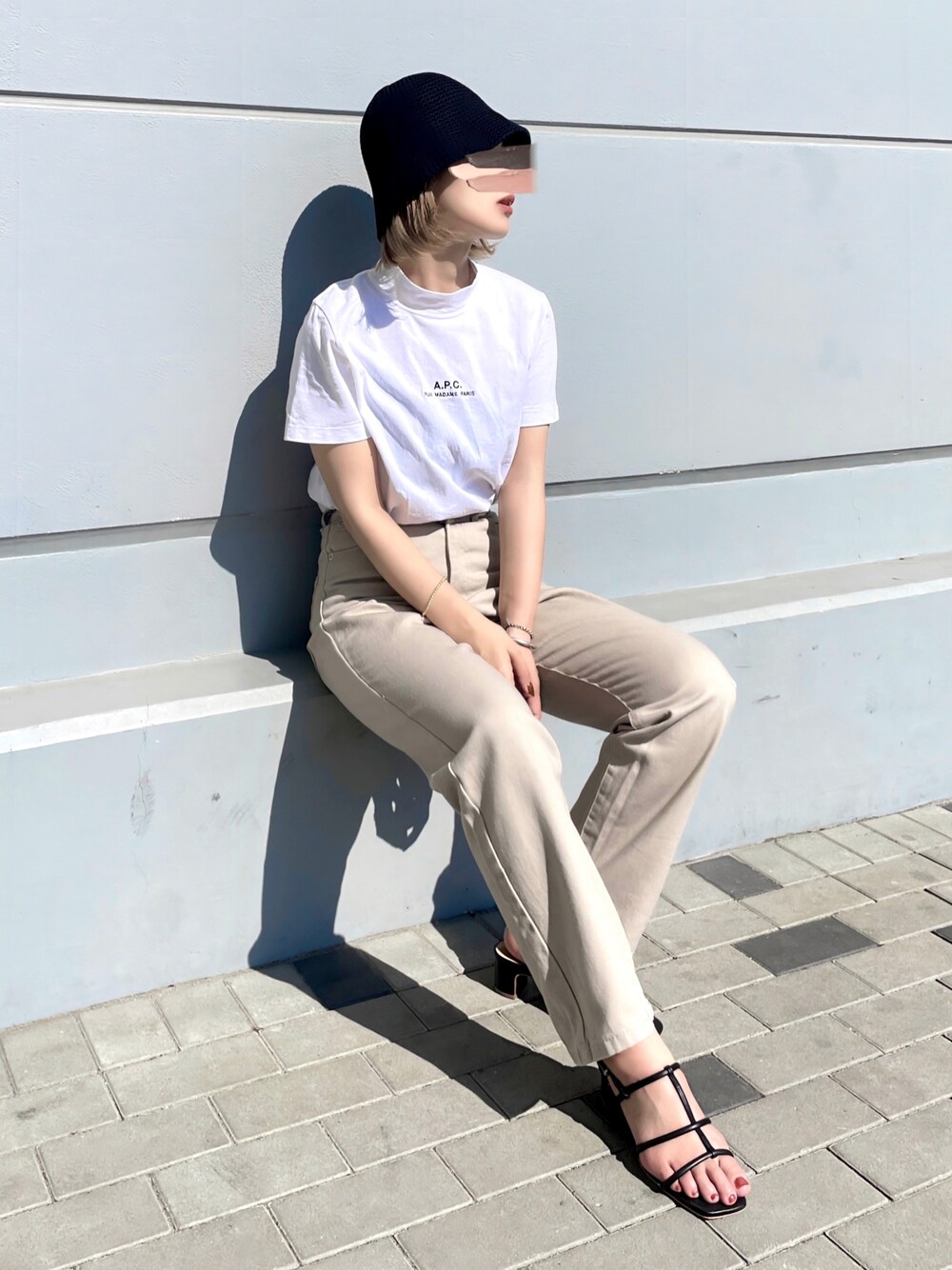 ベージュ系のデニムパンツ、ホワイト系のTシャツ/カットソー、ブラック系のサンダルを着用したレディースの夏コーディネートの1枚目の写真