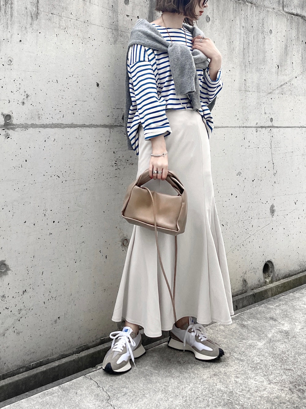 ブルー系のTシャツ/カットソー、ホワイト系のスカート、ブラウン系のショルダーバッグを着用したレディースの春コーディネートの1枚目の写真