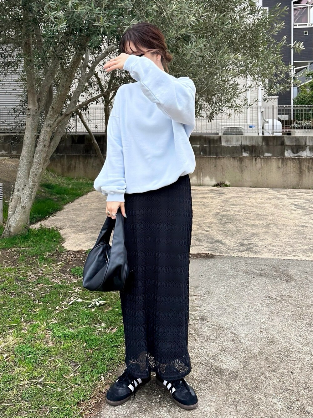 ブルー系のスウェット、ブラック系のハンドバッグ、ブラック系のスニーカーを着用したレディースの春コーディネートの1枚目の写真