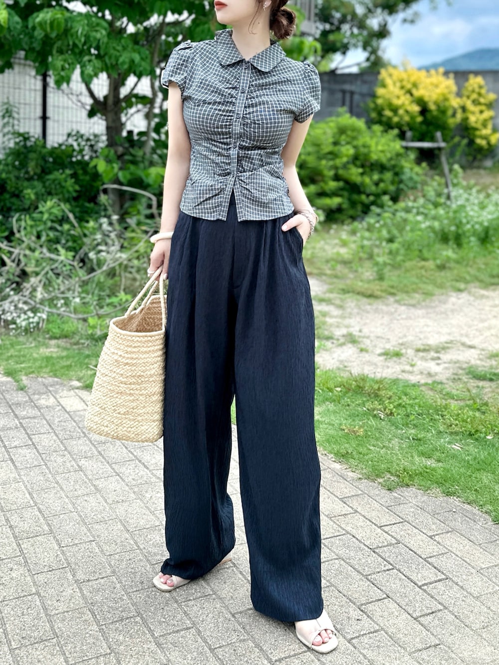 ブラック系のシャツ/ブラウス、ブルー系のデニムパンツ、ベージュ系のかごバッグを着用したレディースの夏コーディネートの1枚目の写真