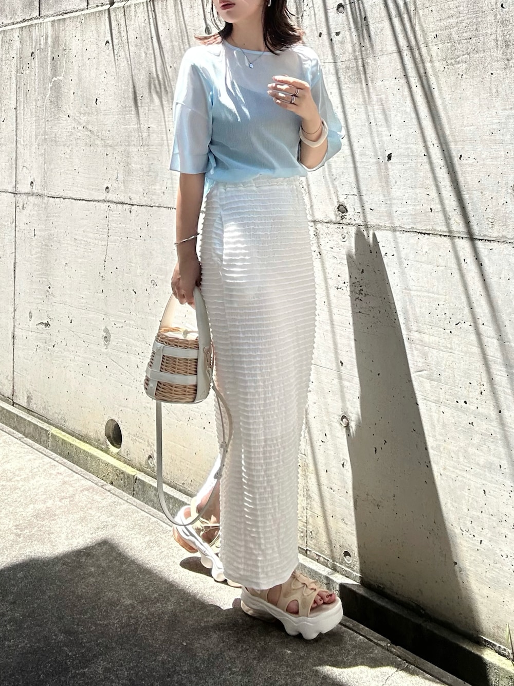 ブルー系のシャツ/ブラウス、ホワイト系のスカート、ホワイト系のかごバッグを着用したレディースの夏コーディネートの1枚目の写真