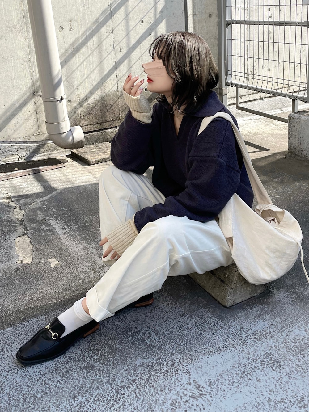 グレー系のニット/セーター、ホワイト系のパンツ、ホワイト系のショルダーバッグを着用したレディースの秋コーディネートの1枚目の写真