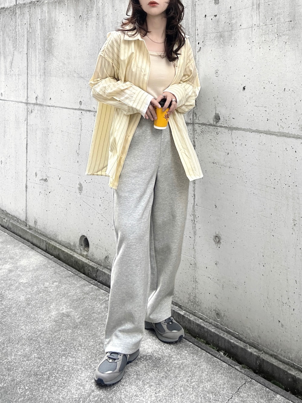 イエロー系のシャツ/ブラウス、ホワイト系のキャミソール、グレー系のスニーカーを着用したレディースの冬コーディネートの1枚目の写真