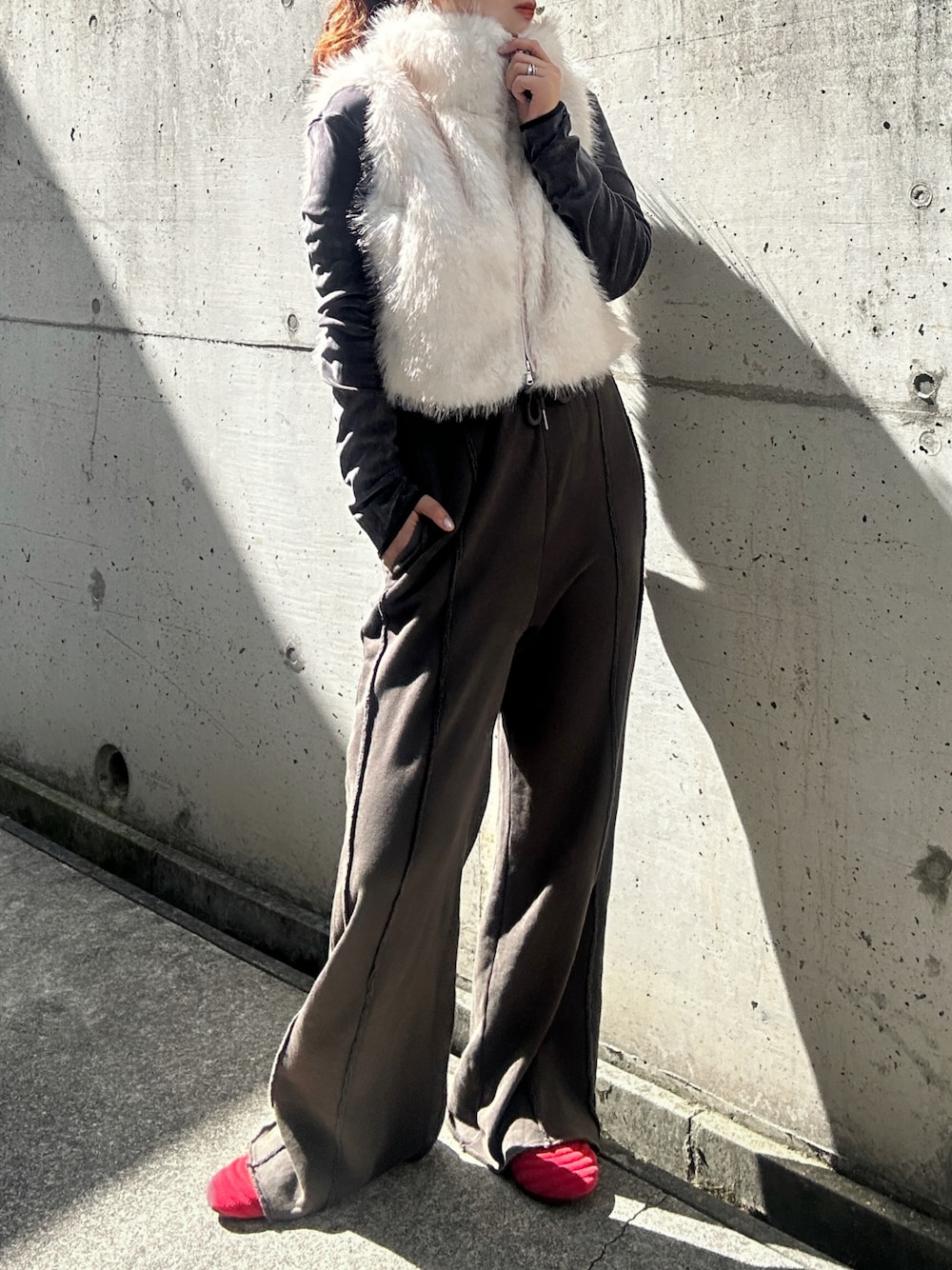 ホワイト系のベスト、グレー系のTシャツ/カットソー、ブラック系のスウェットパンツを着用したレディースの秋コーディネートの1枚目の写真