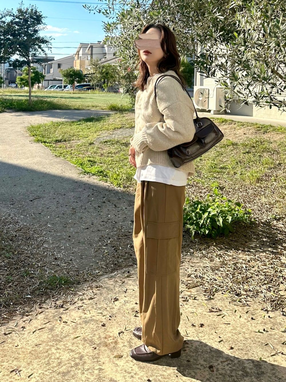 ベージュ系のニット/セーター、ブラウン系のパンツ、ブラウン系のショルダーバッグを着用したレディースの秋コーディネートの1枚目の写真