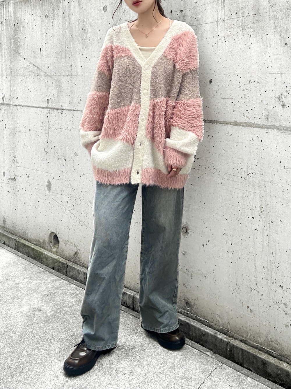 ホワイト系のカーディガン/ボレロ、ホワイト系のキャミソール、ブルー系のデニムパンツを着用したレディースの秋コーディネートの1枚目の写真