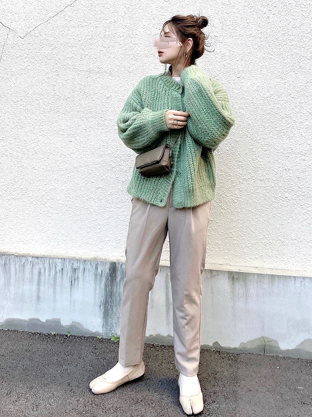 グリーン系のカーディガン/ボレロ、ホワイト系のニット/セーター、ベージュ系のその他パンツを着用したレディースの秋コーディネートの1枚目の写真