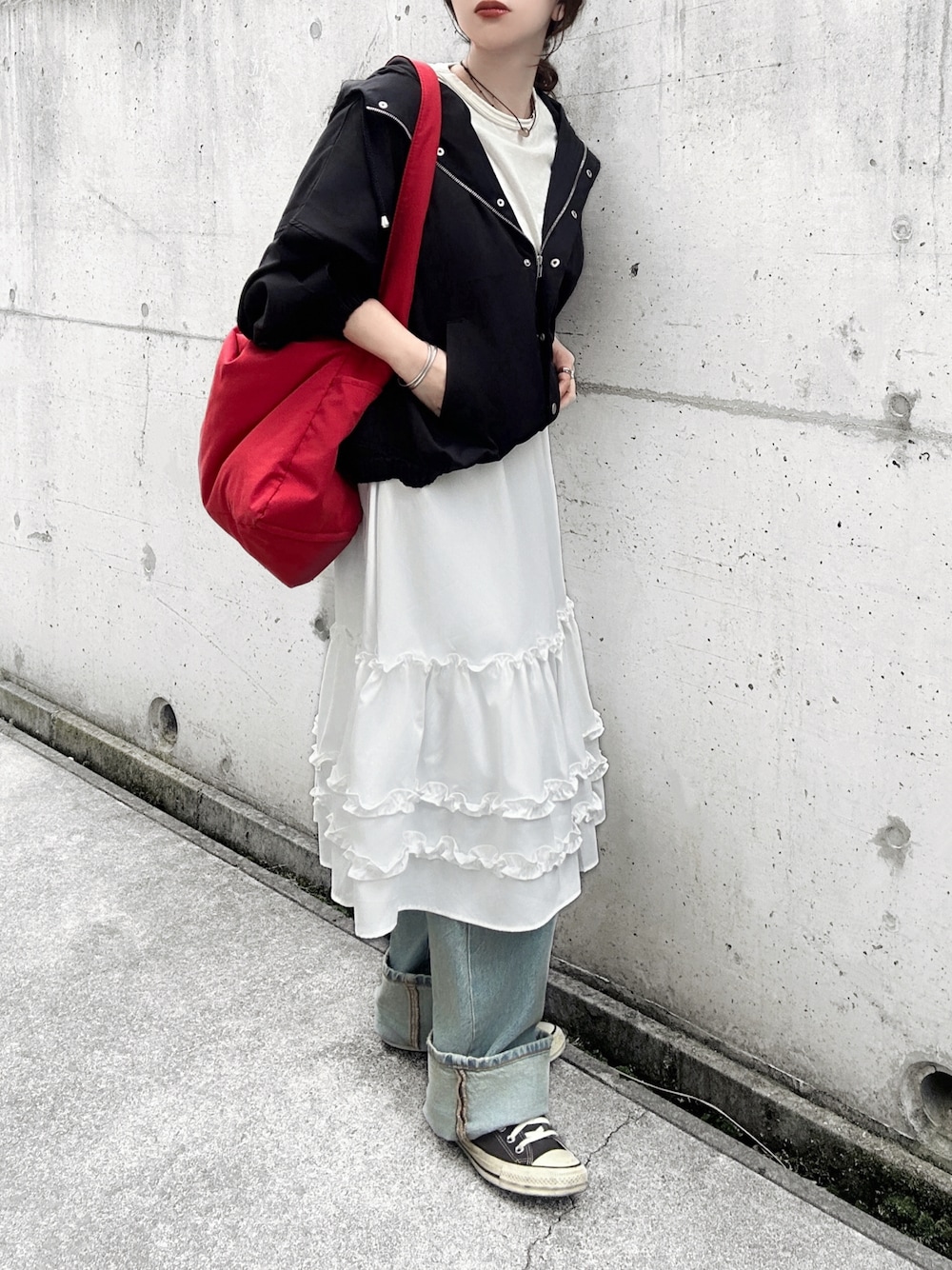 ブラック系のマウンテンパーカー、ホワイト系のスカート、ホワイト系のTシャツ/カットソーを着用したレディースの春コーディネートの1枚目の写真