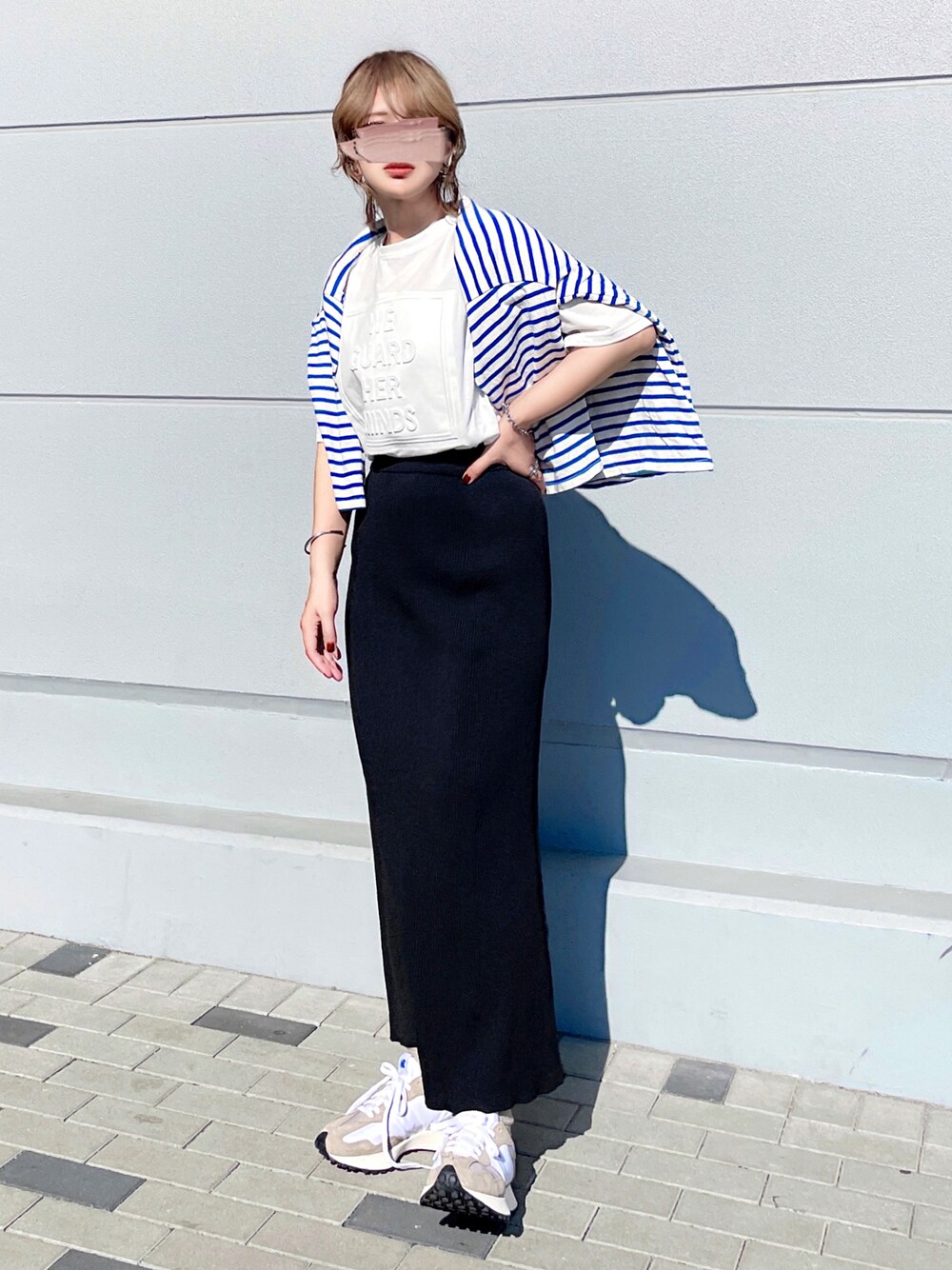ホワイト系のTシャツ/カットソー、ブルー系のTシャツ/カットソー、ブラック系のスカートを着用したレディースの春コーディネートの1枚目の写真