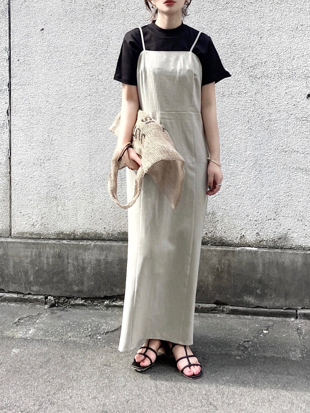 ホワイト系のワンピース、ブラック系のTシャツ/カットソー、ベージュ系のトートバッグを着用したレディースの春コーディネートの1枚目の写真