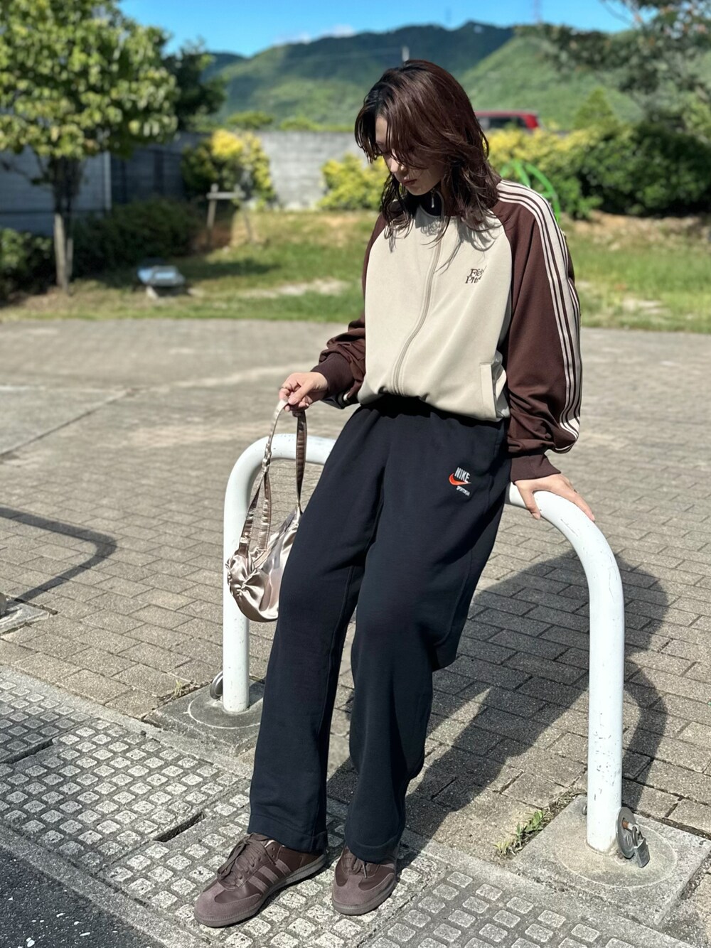 ベージュ系のジャージ、ブラック系のスウェットパンツ、ブラウン系のスニーカーを着用したレディースの秋コーディネートの1枚目の写真
