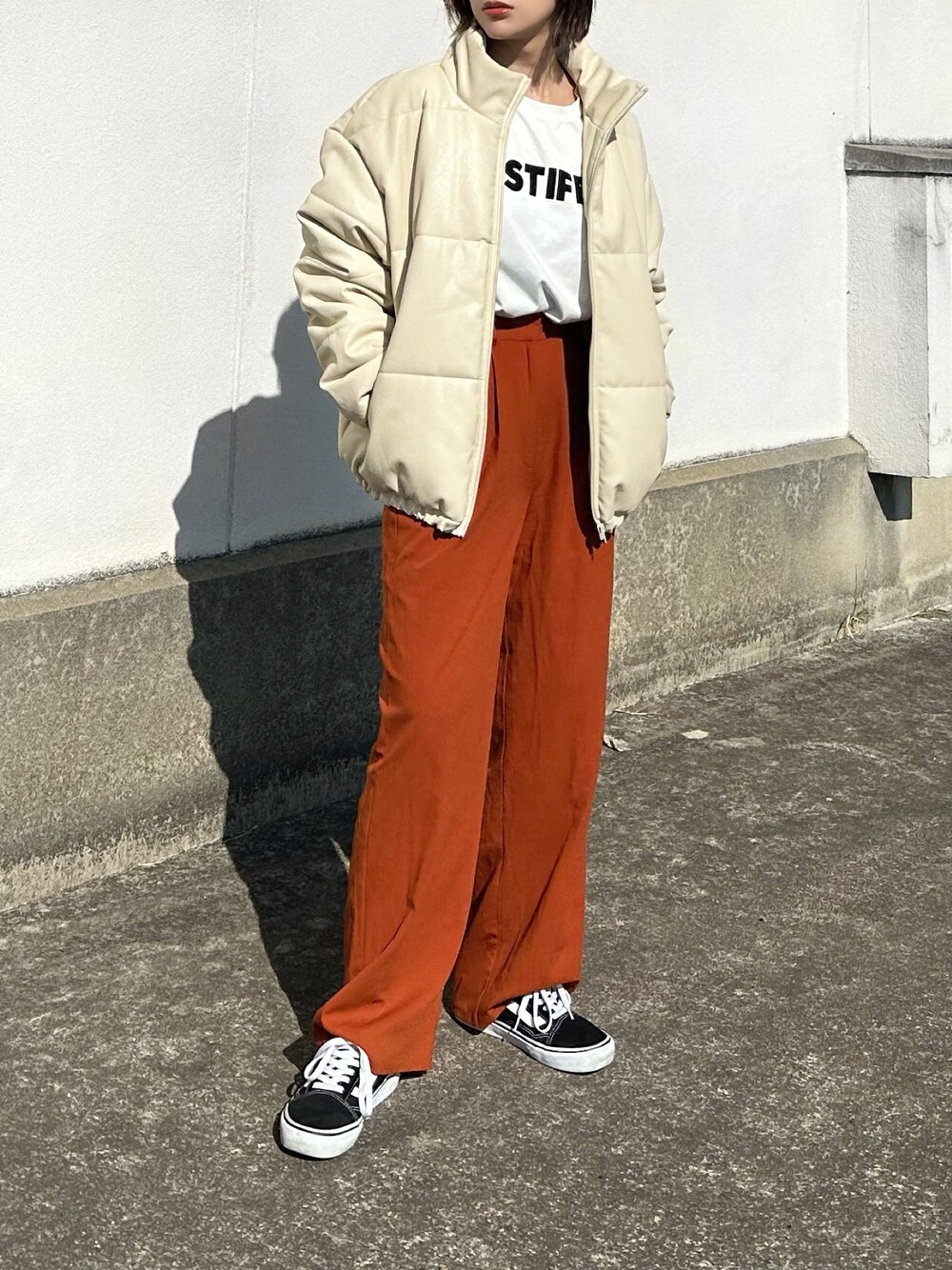 ホワイト系のダウンジャケット/コート、ホワイト系のTシャツ/カットソー、ブラウン系のその他パンツを着用したレディースの秋コーディネートの1枚目の写真