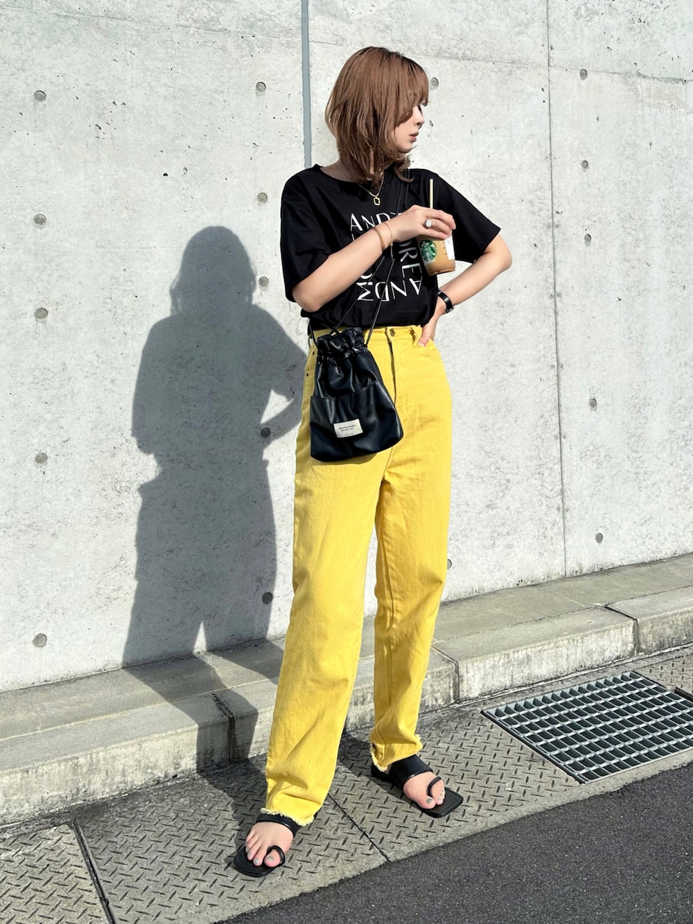 ブラック系のTシャツ/カットソー、イエロー系のデニムパンツ、ブラック系のショルダーバッグを着用したレディースの夏コーディネートの1枚目の写真