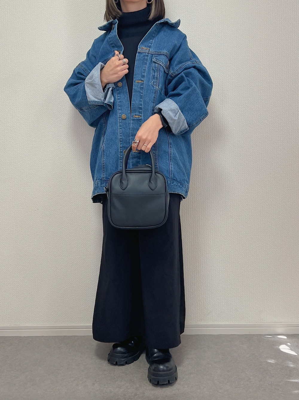 ブルー系のデニムジャケット、ブラック系のショルダーバッグを着用したレディースの冬コーディネートの1枚目の写真