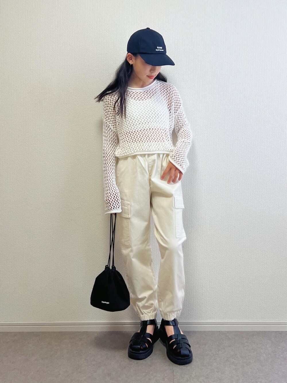 ホワイト系のTシャツ/カットソー、ブラック系のショルダーバッグ、ホワイト系のサンダルを着用したキッズの春コーディネートの1枚目の写真