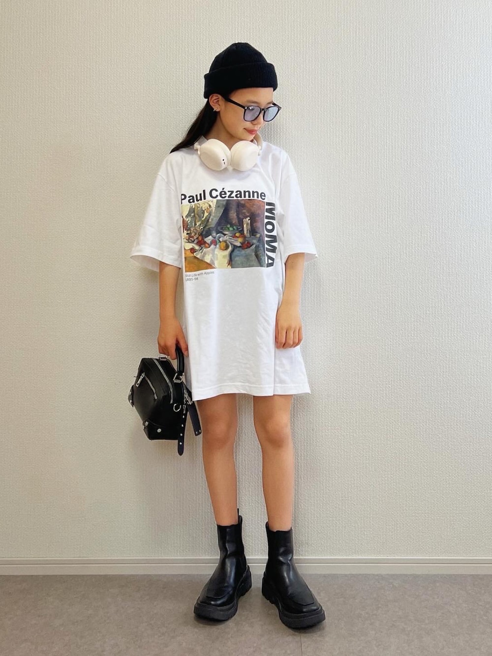 ブラック系のボストンバッグ、ブラック系のブーツ、ホワイト系のTシャツ/カットソーを着用したキッズの夏コーディネートの1枚目の写真