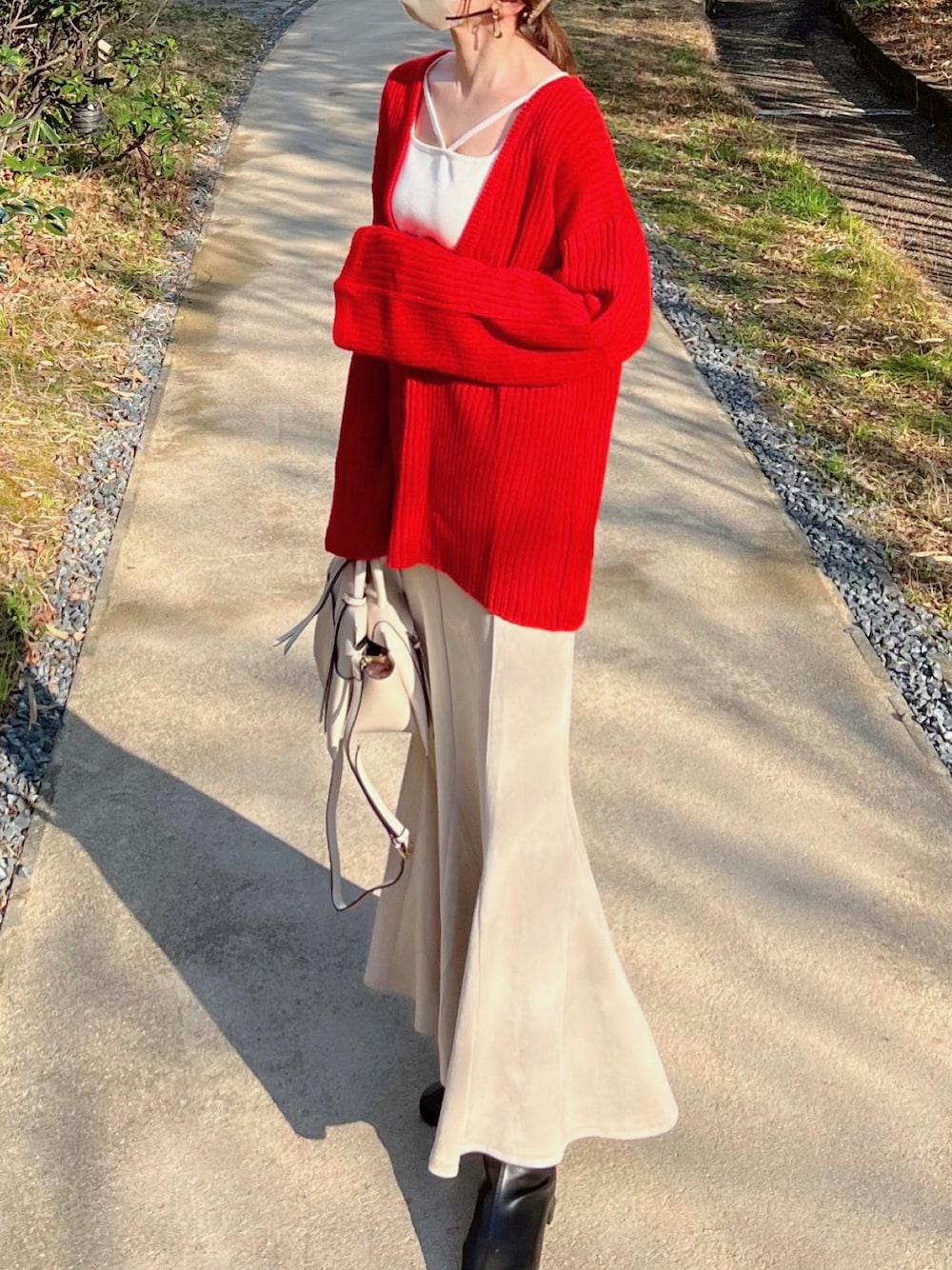 ホワイト系のTシャツ/カットソー、レッド系のニット/セーター、ホワイト系のスカートを着用したレディースの冬コーディネートの1枚目の写真