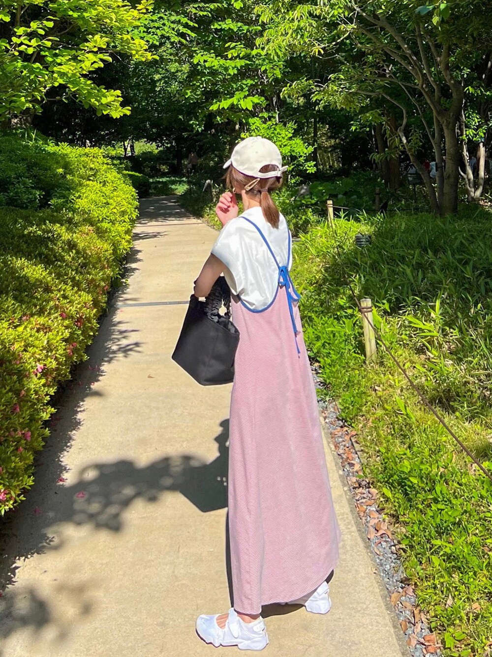 ピンク系のワンピース、ホワイト系のTシャツ/カットソー、ブラック系のトートバッグを着用したレディースの春コーディネートの1枚目の写真