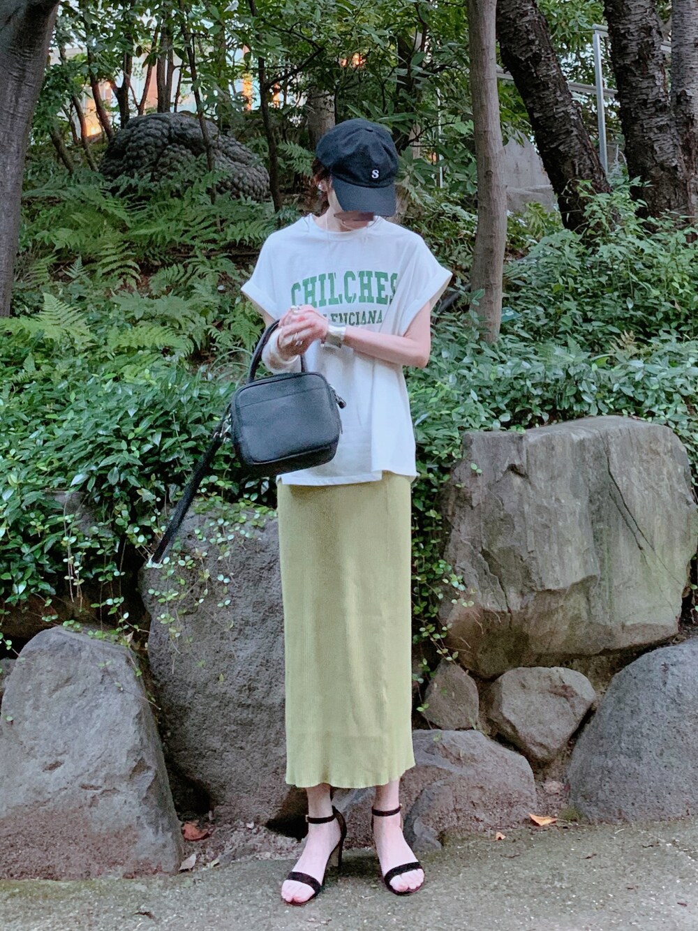 ホワイト系のTシャツ/カットソー、イエロー系のスカート、ブラック系のショルダーバッグを着用したレディースの秋コーディネートの1枚目の写真