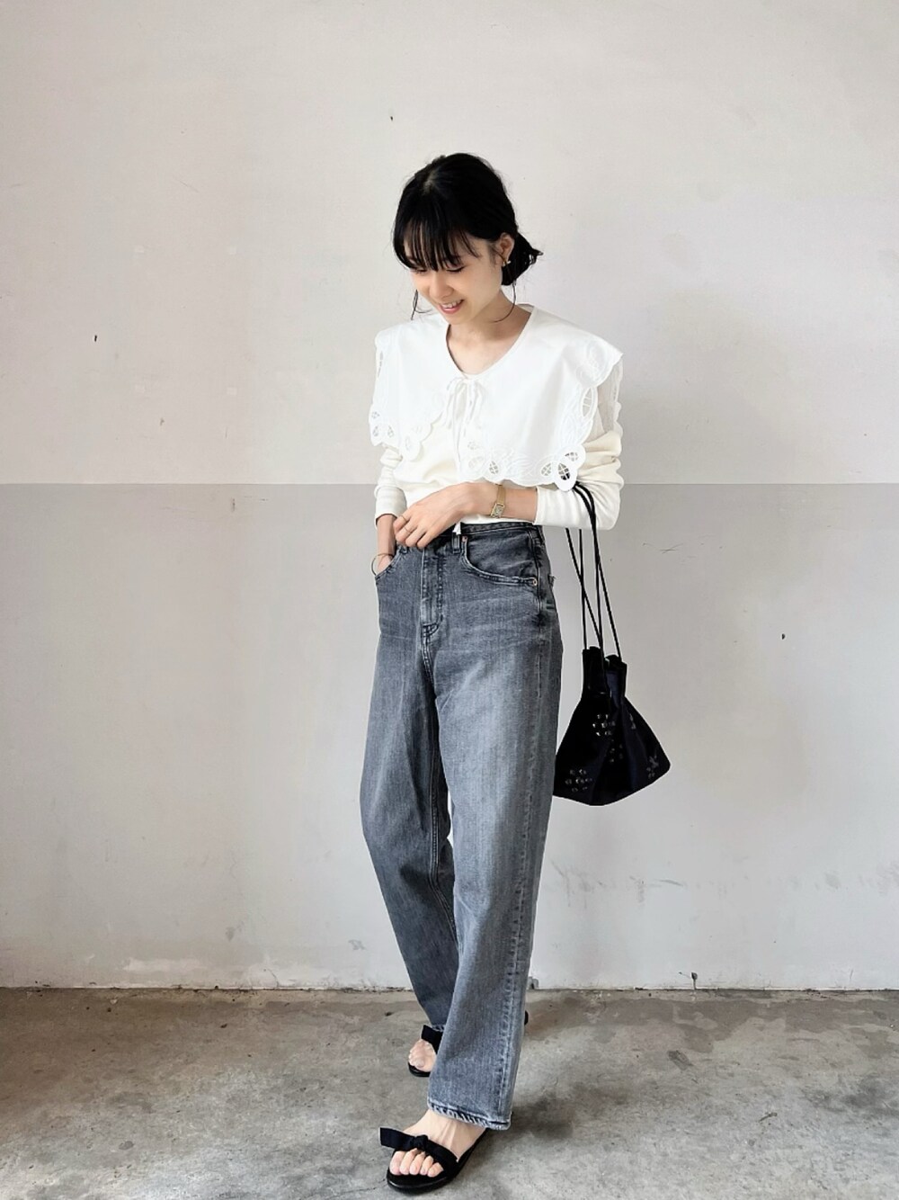 ホワイト系のTシャツ/カットソー、ブラック系のハンドバッグ、グレー系のデニムパンツを着用したレディースの秋コーディネートの1枚目の写真