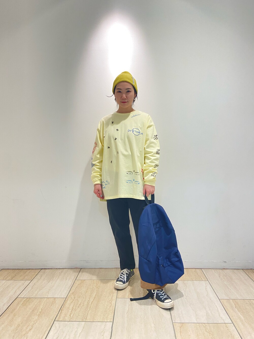 「カジュアルコーデ、オトナカジュアル、ラクチンコーデ、差し色、ロンT、黒パンツ、リュック、BEAVER、BEAVER名古屋、ニット帽」｜「CAL O LINEのCAL O LINE × BEAVER / キャルオーライン×ビーバー　別注 MULTI PRINT L/S TEE マルチプリントロングスリーブティー（Tシャツ/カットソー、イエロー系）」を使った、小林さん（レディース・155cm）の冬コーディネートの1枚目の写真