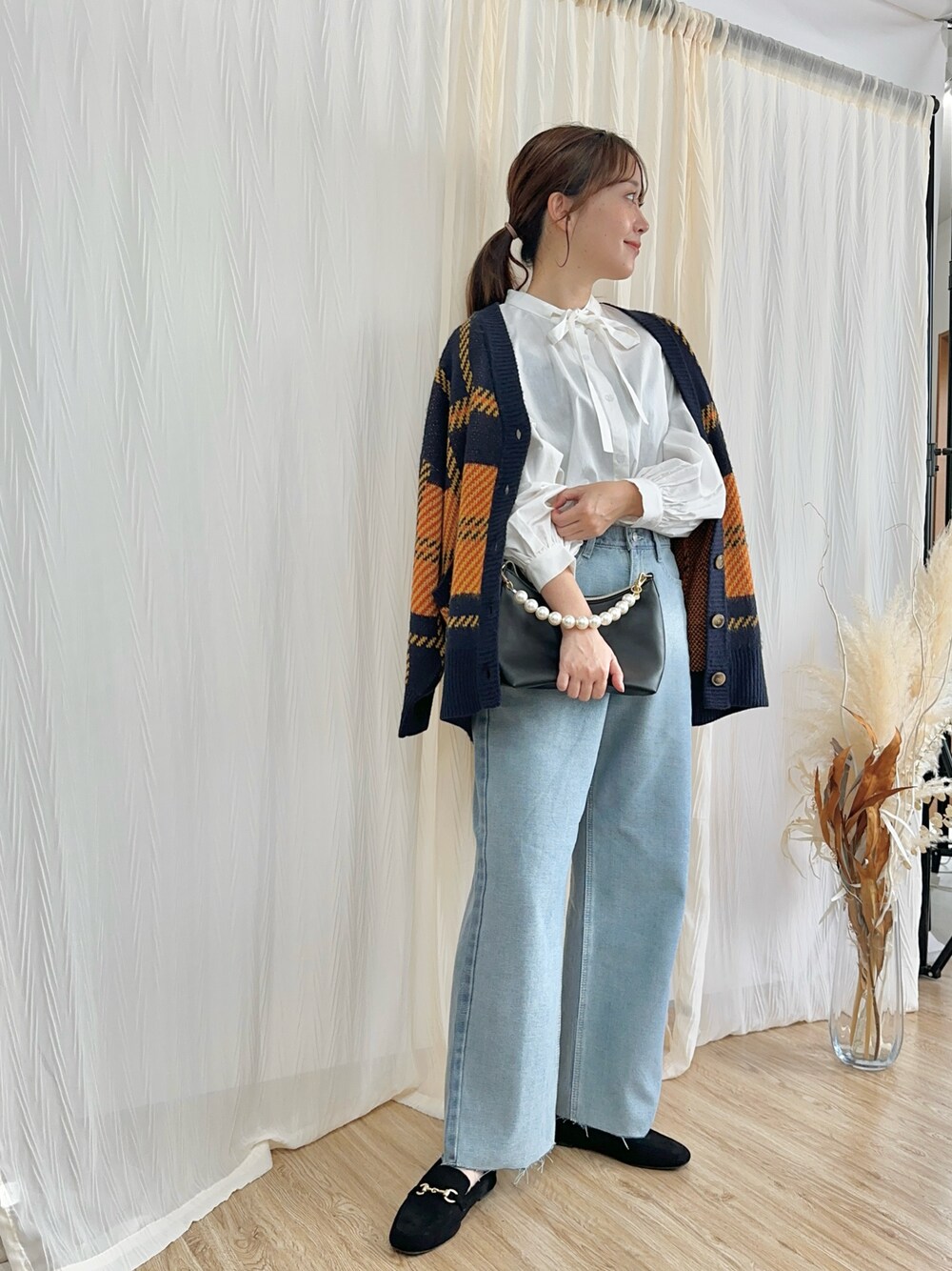 ホワイト系のシャツ/ブラウス、ブルー系のカーディガン/ボレロ、ブルー系のデニムパンツを着用したレディースの秋コーディネートの1枚目の写真