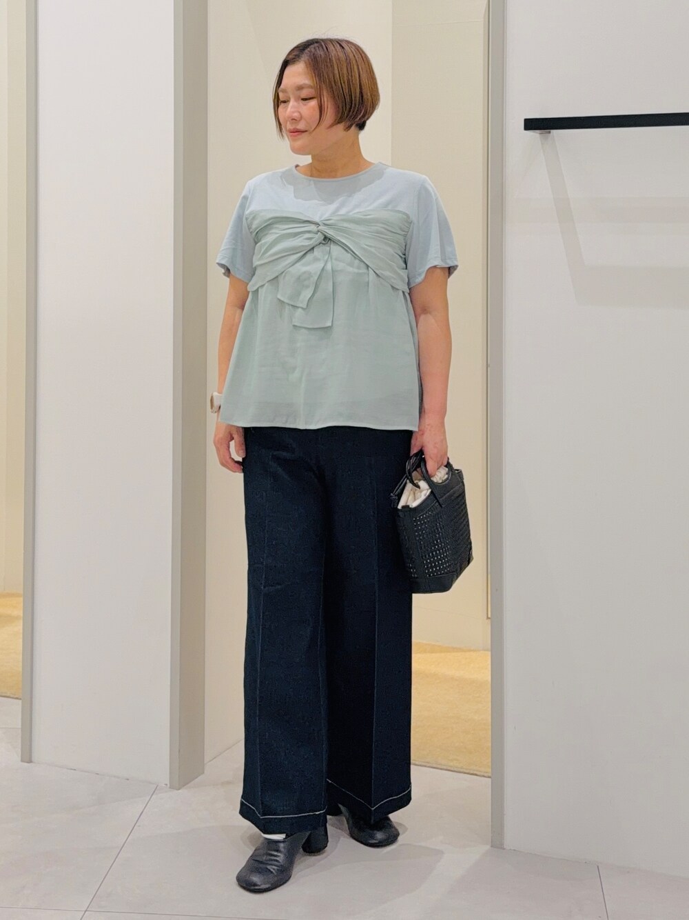 グリーン系のTシャツ/カットソー、ブラック系のデニムパンツ、グリーン系のショルダーバッグを着用したレディースの夏コーディネートの1枚目の写真