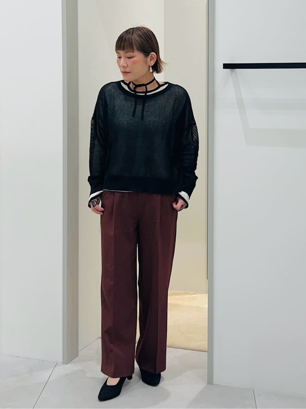 ブラック系のニット/セーター、ホワイト系のニット/セーター、ブラウン系のその他パンツを着用したレディースの春コーディネートの1枚目の写真